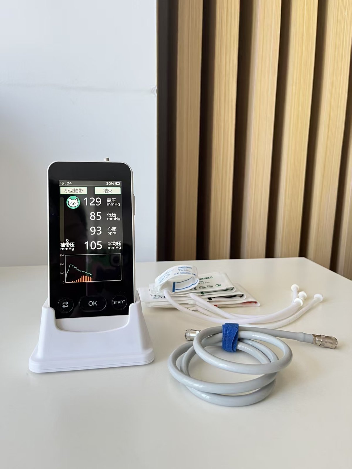 V-E4D blood pressure monitor on a desk with cuff and extension hose