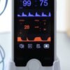 VE4 vital signs monitor docked in its charging base with the SpO2 sensor cable connected